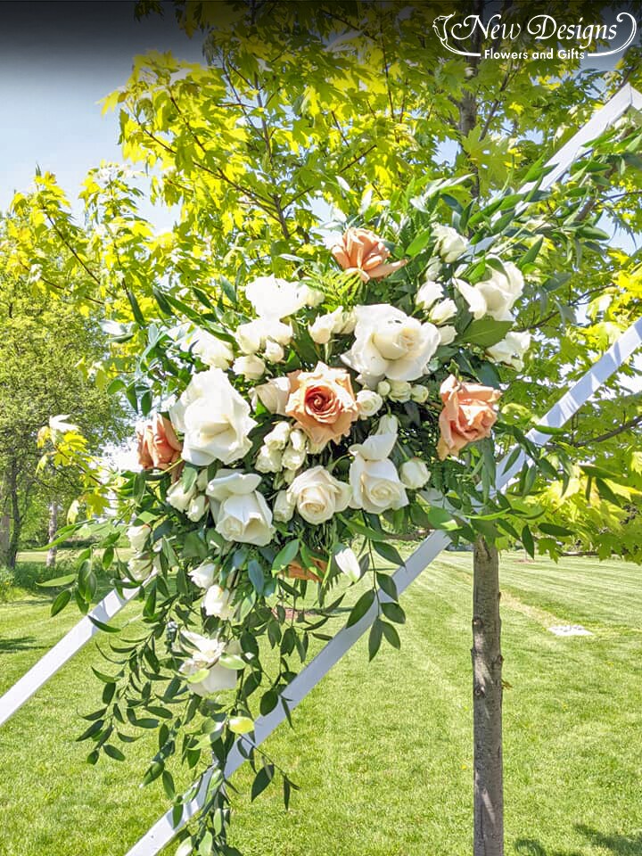 A Double Diamond Arch closeup of 1 installment of florals, with large white roses and Large Toffee Roses,